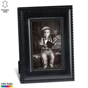 Crni kožni ram za fotografije marke Princ Leather sa ugraviranim kružnim detaljima; unutra se nalazi crno-bela fotografija dečaka u retro odeći koji drži otvorenu knjigu.