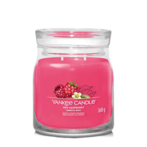 Sveća u staklenoj posudi sa natpisom Yankee Candle Red Raspberry i ilustracijom malina.